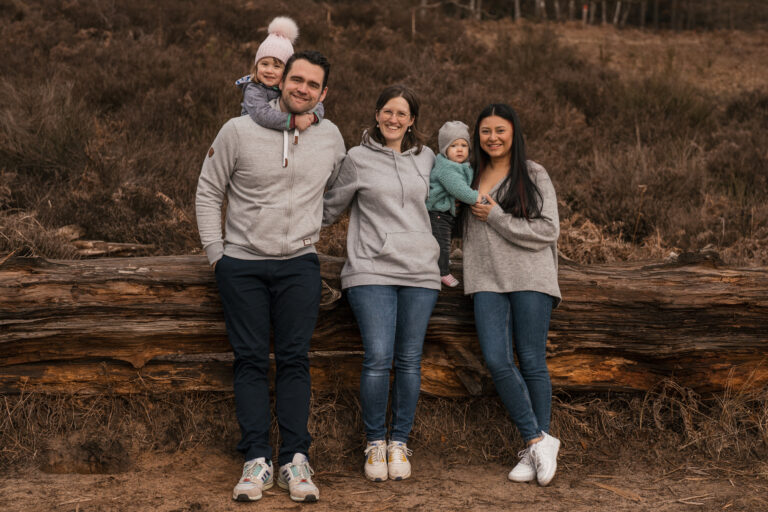 Foto einer 5-köpfigen Familie in der Natur. Die 2 jüngsten Kinder sind in den Armen der Eltern. - Familienshooting Outfit Tipps